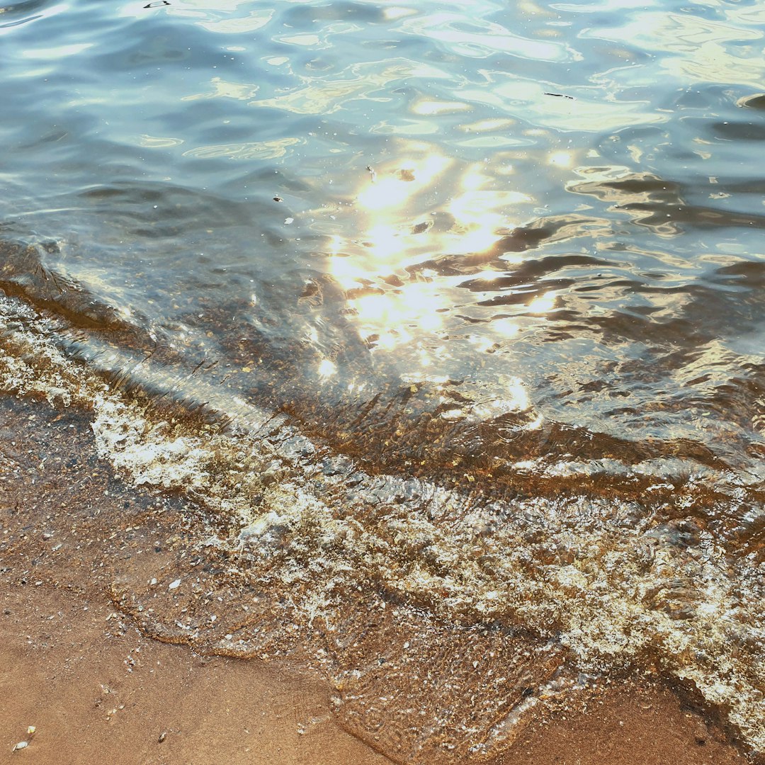 the sun shines through the water on the beach